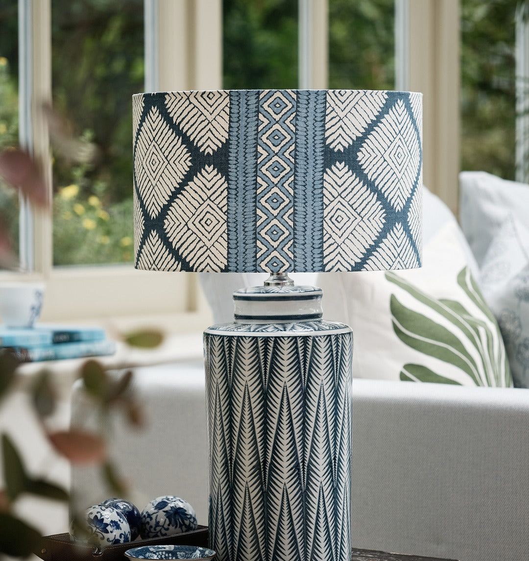 Decorative lamp with a patterned shade on a table in a home setting
